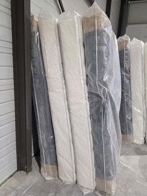 de nombreux matelas empilés les uns à côté des autres devant un immeuble