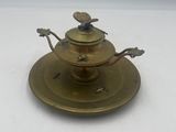 une assiette en laiton ornée d'un oiseau, surmontée d'une soucoupe