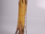 a glass vase with a banana in it on a table