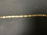 gros plan d'un bracelet en or sur une surface noire