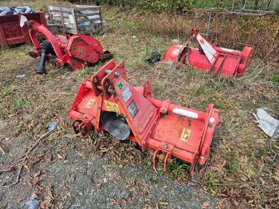 un tracteur rouge assis dans l'herbe