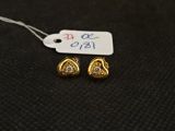 une paire de boucles d'oreilles en or et diamants sur une surface noire