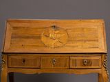 a small wooden desk with drawers and a clock on top of it