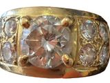 an image of a gold ring with a large diamond surrounded by smaller diamonds
