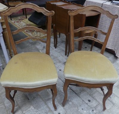 une paire de chaises anciennes avec des assises rembourrées dans une pièce