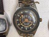 many different types of watches displayed on a table