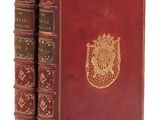 un vieux livre rouge avec un emblème doré sur la couverture