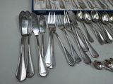 a lot of silverware on a table with a blue box