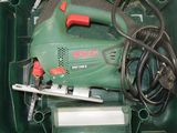 a green box with a green and red power tool inside of it