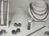 many different types of jewelry on display in a glass case