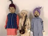 trois poupées représentant des hommes indiens en costume traditionnel, debout les unes à côté des autres