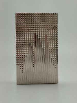 un briquet argenté posé sur une table blanche