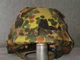 a camouflage helmet on a stand on the floor