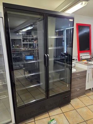 a refrigerator in the middle of a kitchen with a laptop on the counter