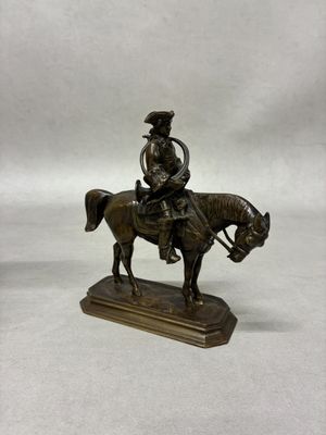bronze figurine of a man on a horse on a white background