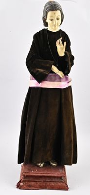 une statue représentant une femme vêtue d'une robe noire et d'une écharpe rose