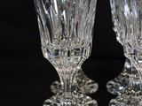 three clear wine glasses sitting on top of each other on a black surface