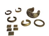 une image représentant un ensemble d'anneaux et de bracelets en laiton posés sur une surface blanche