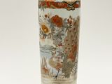 un vase orné d'une peinture posé sur une surface blanche