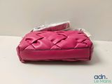 pink leather purse with a matching wrist strap and a matching wrist strap