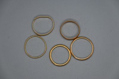 cinq anneaux dorés sont disposés en cercle sur une surface blanche