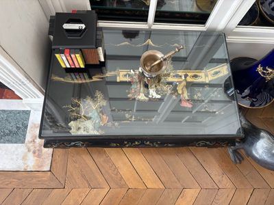 une table en verre sur laquelle se trouve un vase, devant une porte
