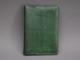 un portefeuille en cuir vert posé sur une table