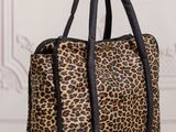 a leopard print handbag sitting on top of a wooden table