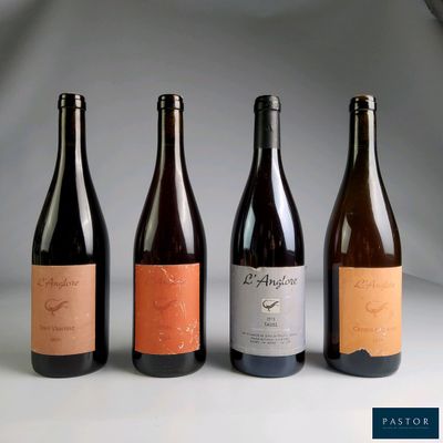 quatre bouteilles de vin sont alignées sur une table