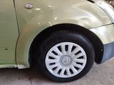 a green car with a black rim parked in a garage