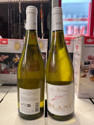 deux bouteilles de vin posées sur une table l'une à côté de l'autre
