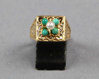une image représentant une bague en or ornée d'une perle et de pierres vertes