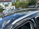 a black car parked in a parking lot with other cars