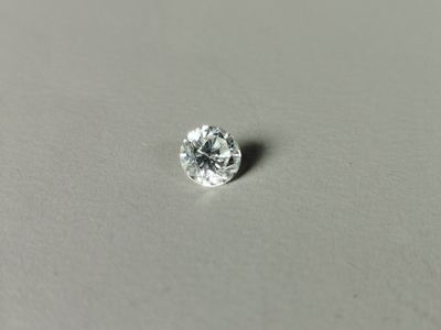 gros plan d'un diamant unique sur une surface blanche