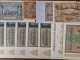 several different types of old paper money sitting on top of a table