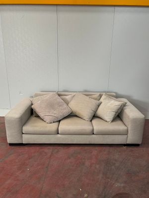 un canapé avec des coussins, placé au milieu d'une pièce