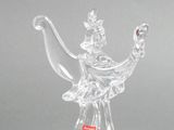 a clear glass figurine of a woman holding a teapot