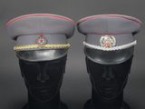 pair of military hats on mannequin heads on a black background