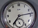 un gros plan d'une montre de poche en argent posée sur une table