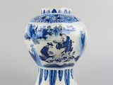 blue and white vase with a man riding a horse in a landscape