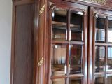 a large wooden cabinet with glass doors in a room