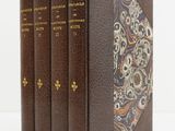 trois livres sont empilés sur une surface blanche