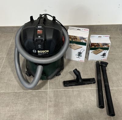 l'aspirateur est posé par terre à côté d'un carton contenant des aspirateurs