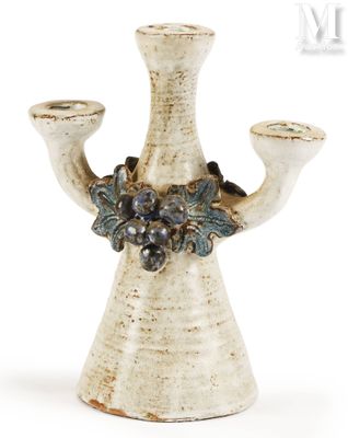 a white vase that has a bunch of grapes on it