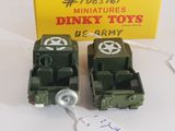 two toy army vehicles sitting next to each other on a table