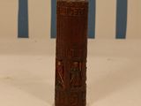 a wooden cylinder with carvings on it on a table