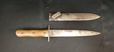Deux couteaux sont posés sur une table, sur laquelle est accrochée une étiquette.