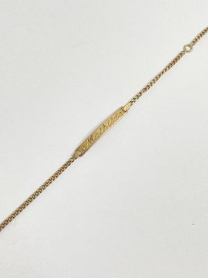 a close up of a gold bracelet on a white surface