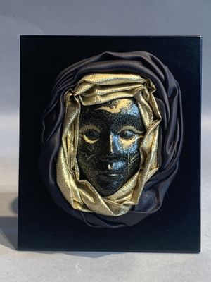 une image représentant une sculpture noir et or représentant le visage d'une femme