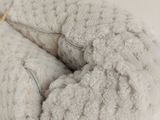 a stuffed animal that is laying down on a white surface